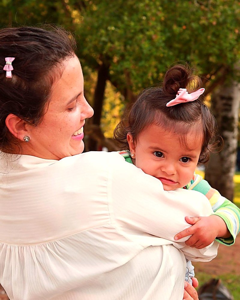 Nany con una pequeña al aire libre